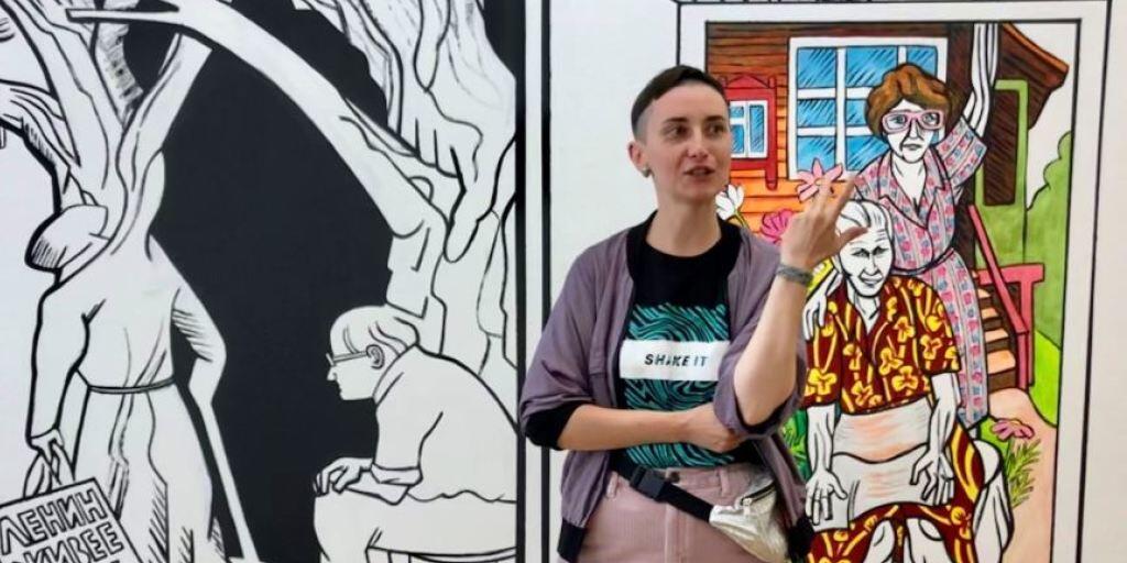 Victoria Lomasko vor ihrem Wandgemälde, das sie als Artist in Residence im Cartoonmuseum Basel geschaffen hat.