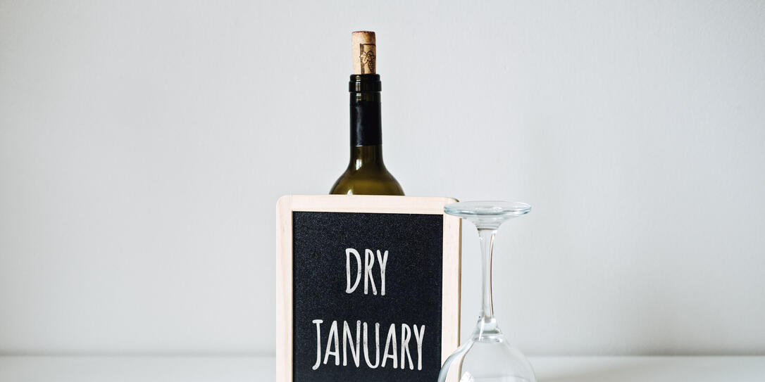 Dry January. Alcohol-free challenge, Health campaign urging people to abstain from alcohol for the January month. Bottle of wine, glass and sign with text Dry January