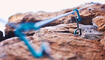 Rock climbing, mountain and closeup of rope and hook for adventure, freedom and extreme sports in nature. Fitness, hiking and carabiner, equipment or gear in stone for training, activity or challenge
