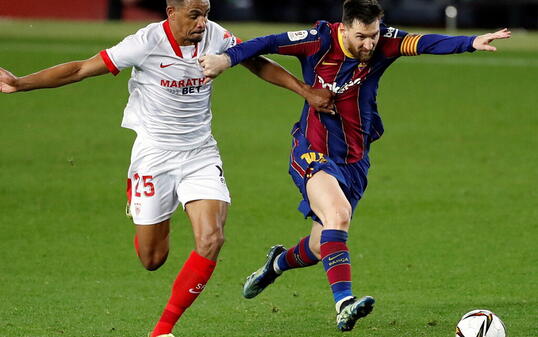 Lionel Messi (rechts) muss sich hier gegen Sevillas Fernando Reges wehren