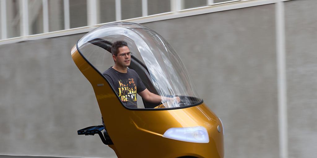 Neigt sich leise surrend in die Kurve: das BiCar, eine Mischung aus Auto und E-Bike