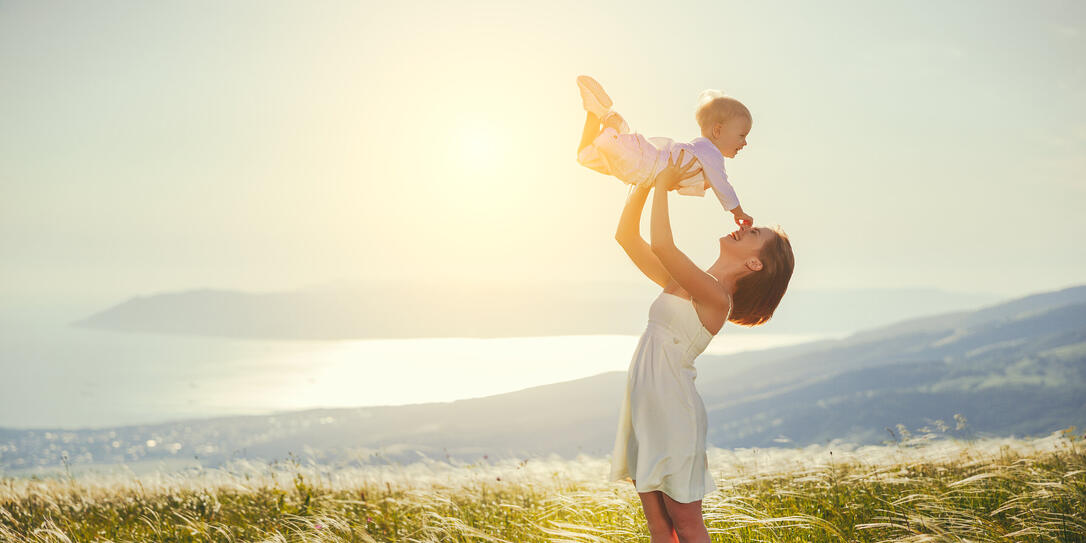 Happy family mother and baby son laughing  in nature