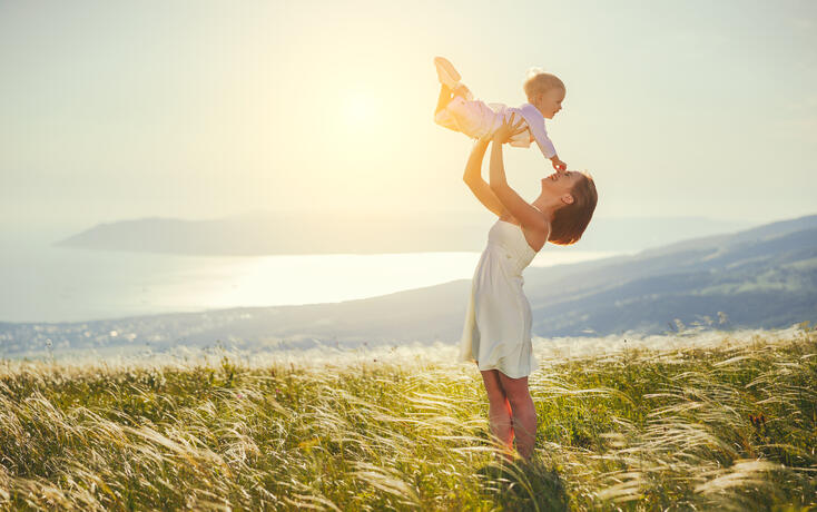 Happy family mother and baby son laughing  in nature