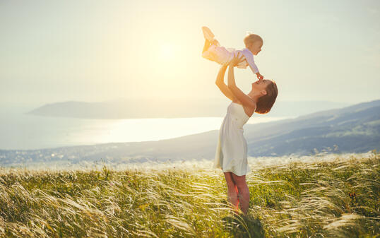 Happy family mother and baby son laughing  in nature