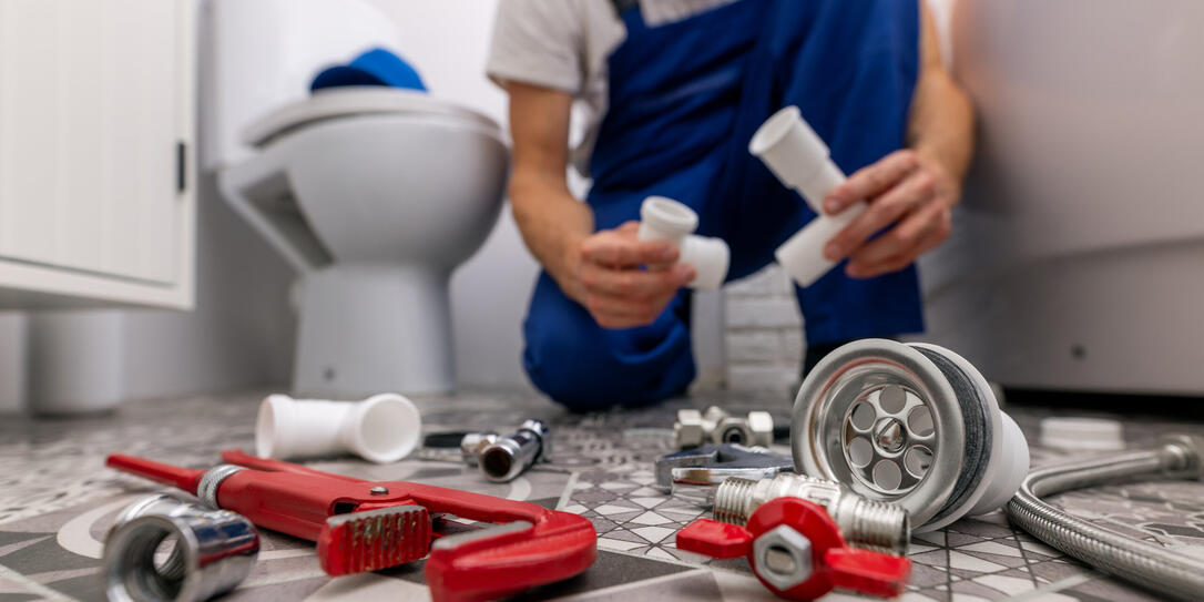plumber working in bathroom. plumbing services plumber working in bathroom. plumbing services