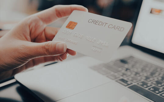 Close-up Attractive woman holding credit card Making Online Payment while online shopping on laptop computer