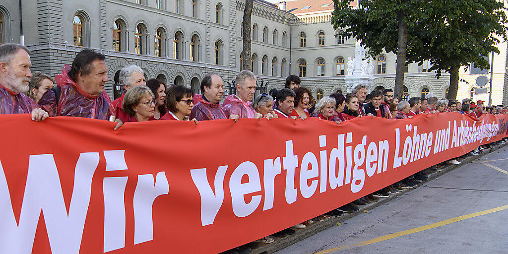 Gewerkschafter vor dem Bundeshaus demonstrieren mit einer "Roten Linie" für die flankierenden Massnahmen.