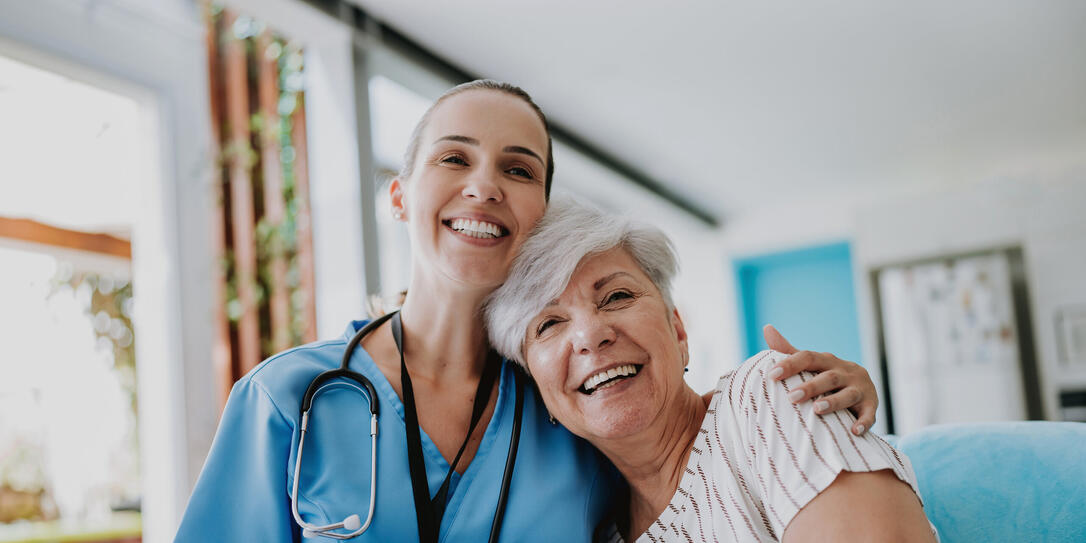 Home care healthcare professional hugging senior patient