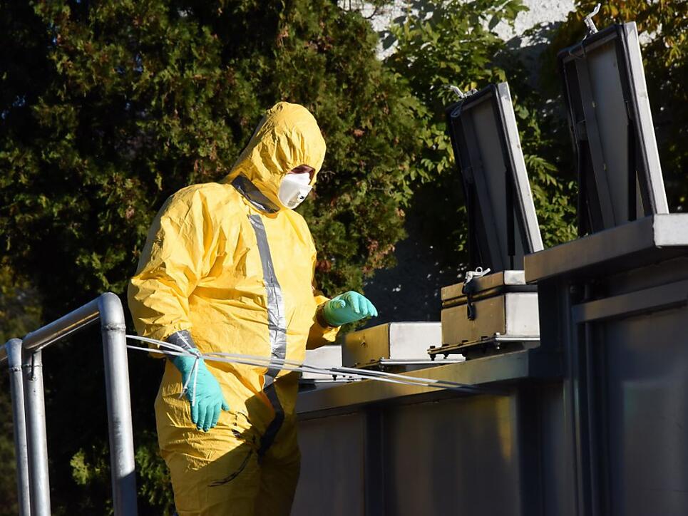 Ein Mann im Isolieranzug vor dem Container, in dem die 6000 getöteten Hühner abtransportiert werden.