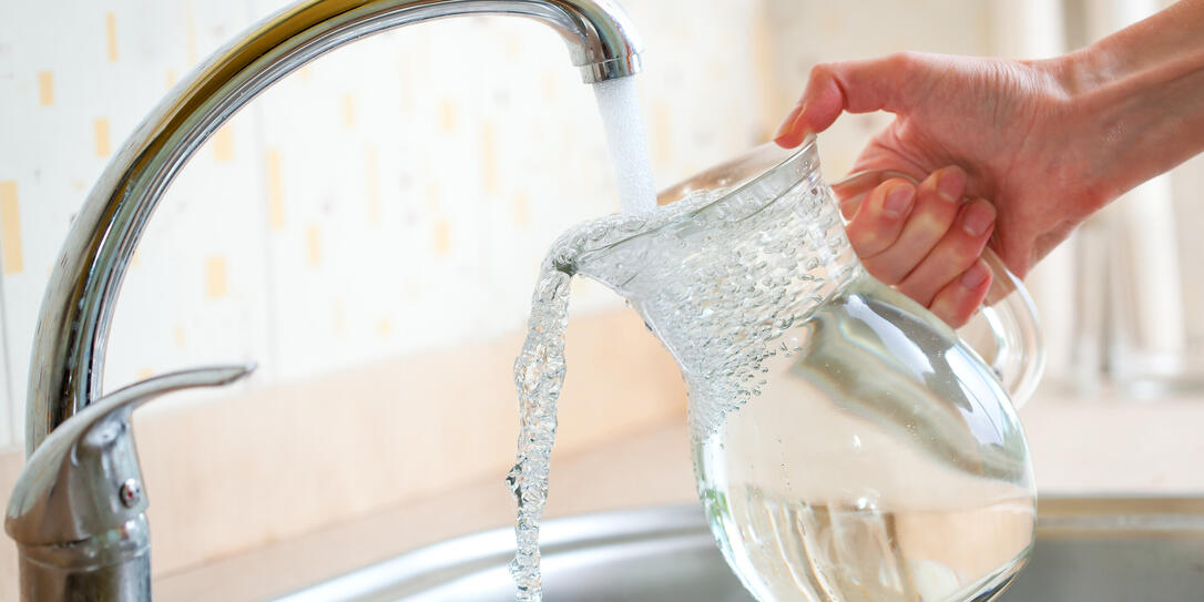 Filling glass pitcher with water Filling glass pitcher with water