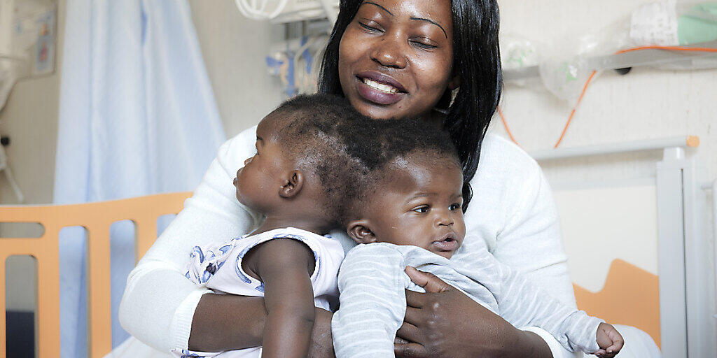 HANDOUT - Ihre Mutter hält die Zwillinge vor der Trennung im April 2019 auf dem Schoß. Italienischen Ärzten ist eine schwierige und seltene Operation zur Trennung von siamesischen Zwillingen gelungen. Foto: Ospedale Pediatrico Bambino Gesù/dpa - ACHTUNG: Nur zur redaktionellen Verwendung im Zusammenhang mit der aktuellen Berichterstattung und nur mit vollständiger Nennung des vorstehenden Credits