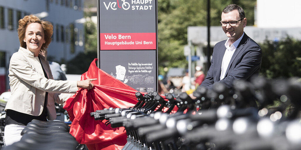 Berns Gemeinderätin Ursula Wyss und Bruno Rohner von PubliBike bei der Enthüllung der Stele vor der Uni Bern.