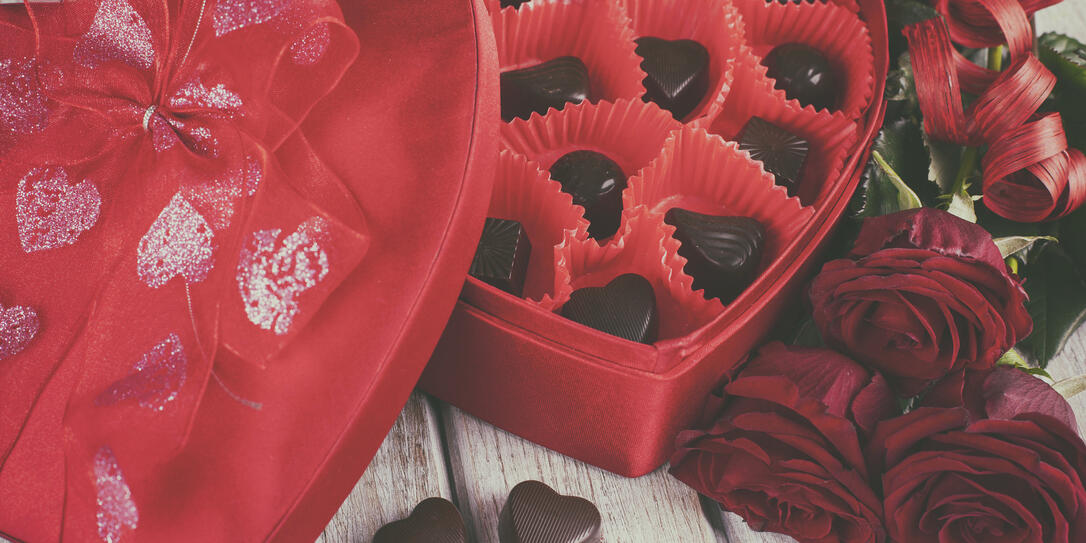 Heart chocolate box and red roses on wooden rustic background