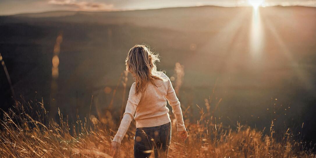 Back view of carefree woman in autumn day on a hill at sunset. Back view of carefree woman in autumn day on a hill at sunset.