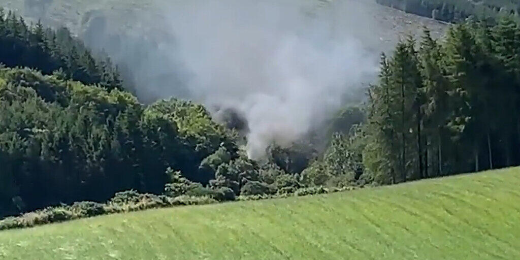 HANDOUT - Dieses von BBC Schottland zur Verfügung gestellte Videostandbild zeigt Rauch, der aus einem entgleisten Zug in der Nähe von Stonehaven, Aberdeenshire, aufsteigt. Foto: BBC Scotland/PA Media/dpa - ACHTUNG: Nur zur redaktionellen Verwendung im Zusammenhang mit der aktuellen Berichterstattung und nur mit vollständiger Nennung des vorstehenden Credits