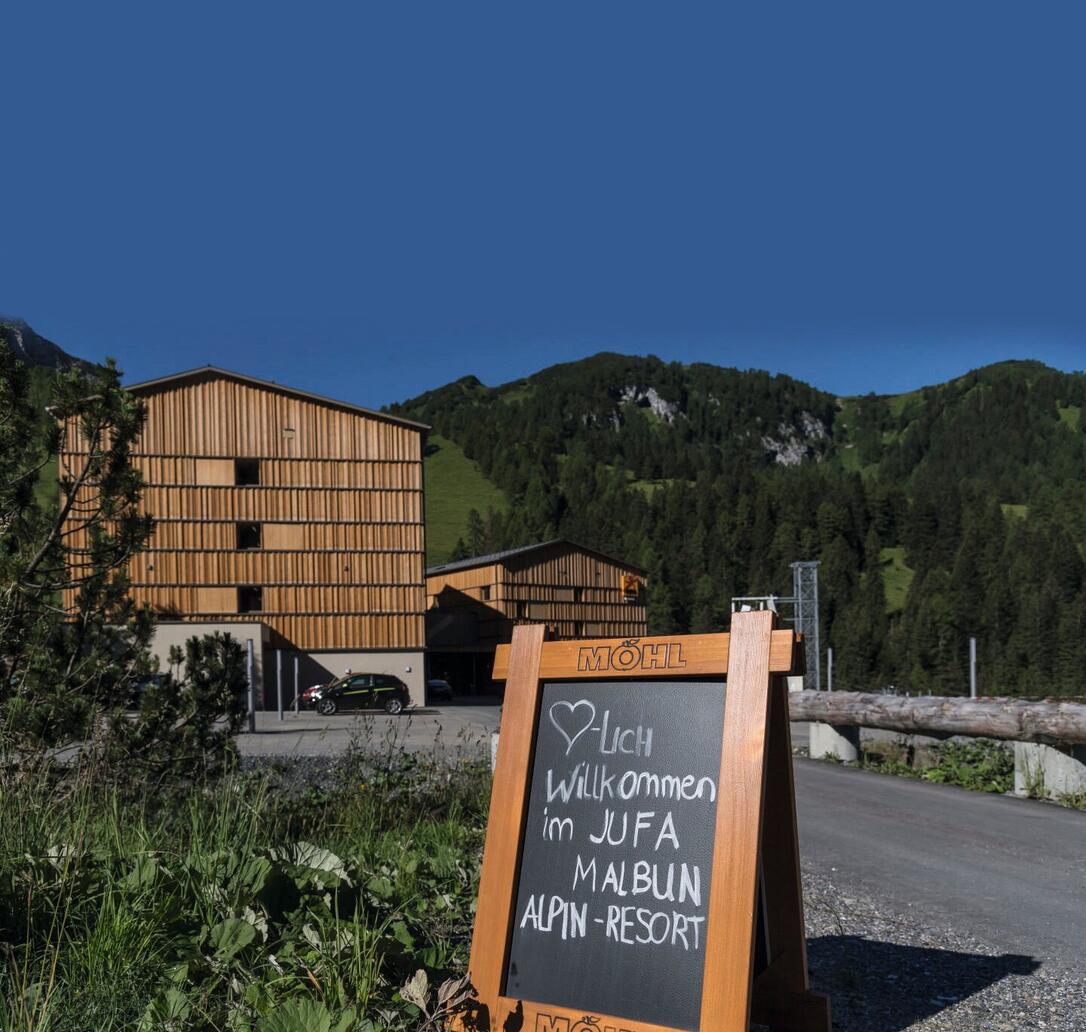Hotelansicht vom JUFA Hotel Malbun Alpin-Resort mit Willkommensgruß