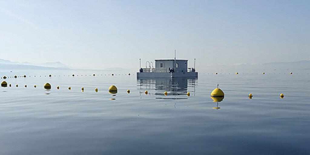 Von Bojen vor dem Schiffsverkehr gesch&uuml;tzt schwimmt die Forschungsstation "L&eacute;xplore" auf dem Genfersee.