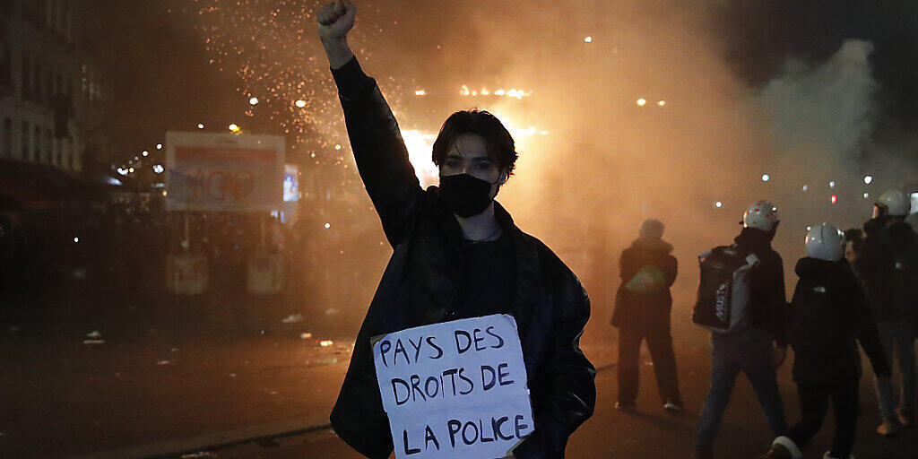 Ein Teilnehmer einer Demonstration hält während eines Protestes gegen ein neues Sicherheitsgesetz ein Schild mit der Aufschrift «Land der Polizeirechte» in der Hand. Foto: Francois Mori/AP/dpa Ein Teilnehmer einer Demonstration hält während eines Protestes gegen ein neues Sicherheitsgesetz ein Schild mit der Aufschrift «Land der Polizeirechte» in der Hand. Foto: Francois Mori/AP/dpa