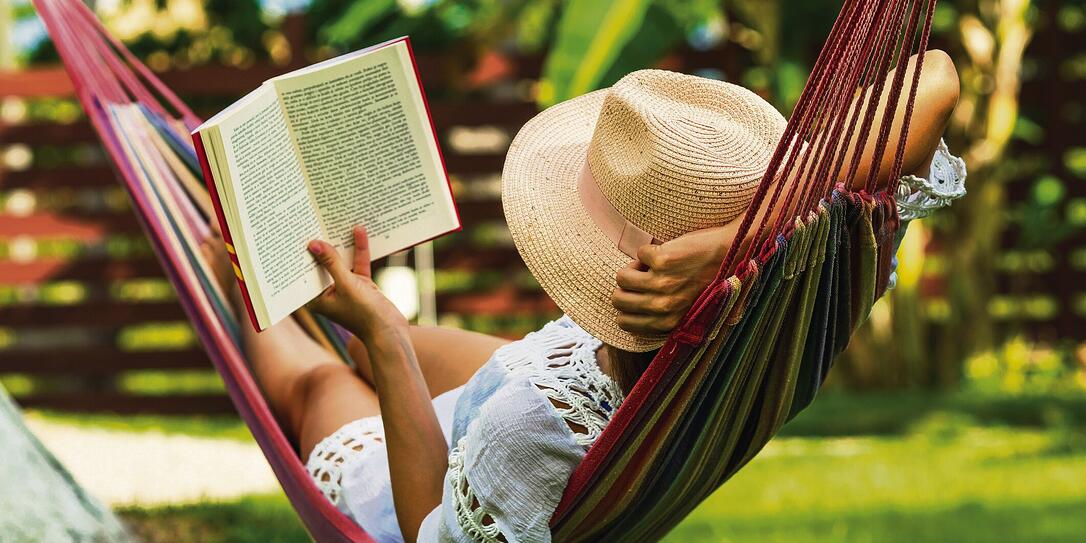 Woman reading book in hammock