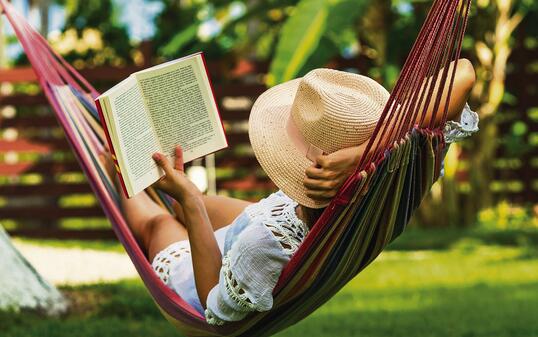 Woman reading book in hammock