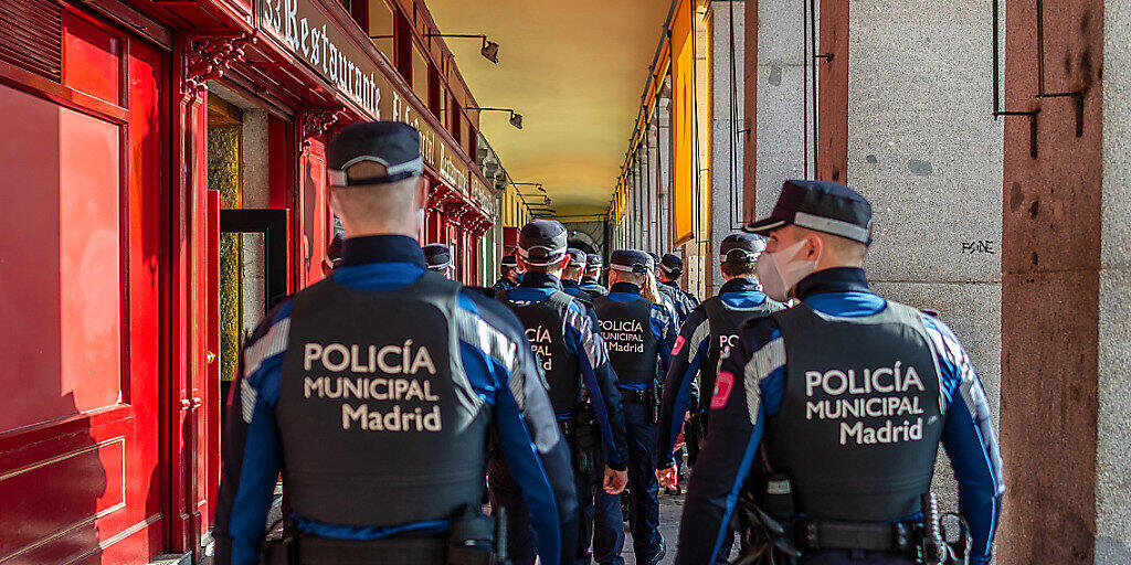 Eine Gruppe Polizisten mit Masken ist in der Stadmitte im Einsatz. Zur weiteren Eindämmung der Corona-Pandemie riegelt sich Madrid zwischen dem 4. und dem 13. Dezember ab. Foto: Diego Radamã©s/Zuma Press/dpa Eine Gruppe Polizisten mit Masken ist in der Stadmitte im Einsatz. Zur weiteren Eindämmung der Corona-Pandemie riegelt sich Madrid zwischen dem 4. und dem 13. Dezember ab. Foto: Diego Radamã©s/Zuma Press/dpa