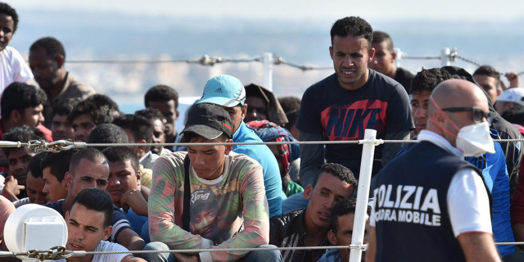 Aus Seenot gerettete Bootsflüchtlinge warten, um in Sizilien an Land gehen zu können.