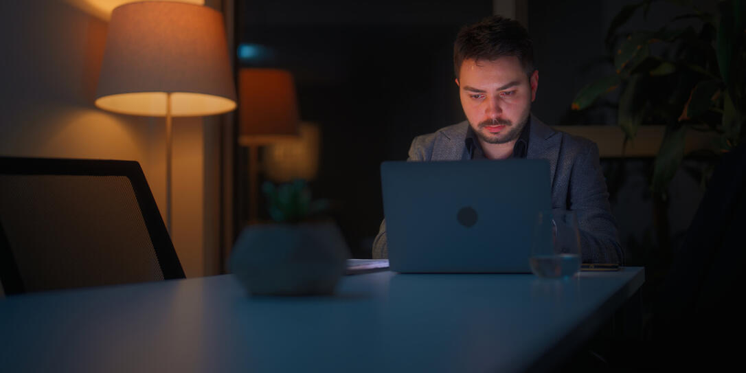 Businessman working alone in office at night
