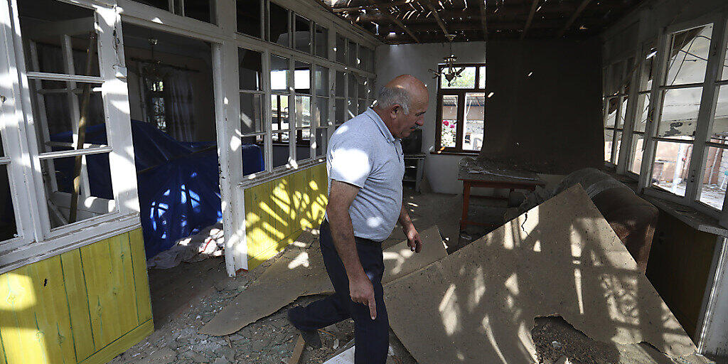 Nach Angriffen armenischer Truppen inspiziert ein Mann sein beschädigtes Haus im aserbaidschanischen Tartar. Foto: Aziz Karimov/AP/dpa Nach Angriffen armenischer Truppen inspiziert ein Mann sein beschädigtes Haus im aserbaidschanischen Tartar. Foto: Aziz Karimov/AP/dpa