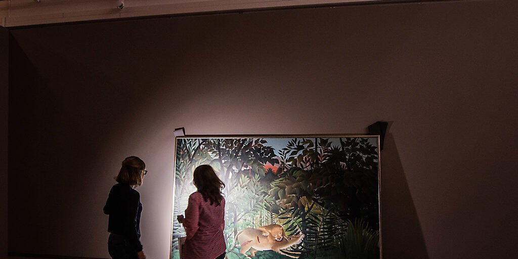 Zwei Restauratorinnen begutachten das Kunstwerk «Der hungrige Loewe wirft sich auf die Antilope» von Henri Rousseau: Das Bild war von Basel nach Frankfurt gereist und wird dort bis 3. Februar zu sehen sein Zwei Restauratorinnen begutachten das Kunstwerk «Der hungrige Loewe wirft sich auf die Antilope» von Henri Rousseau: Das Bild war von Basel nach Frankfurt gereist und wird dort bis 3. Februar zu sehen sein