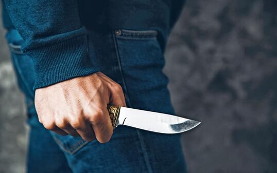 man hand holding knife on abstract background