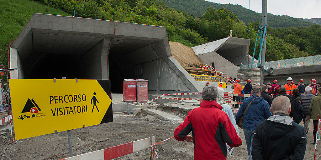 Besucher mit Schutzhelmen machen sich am Tunnelportal bereit für die Besichtigung im Ceneri Tunnel. (Archivbild)