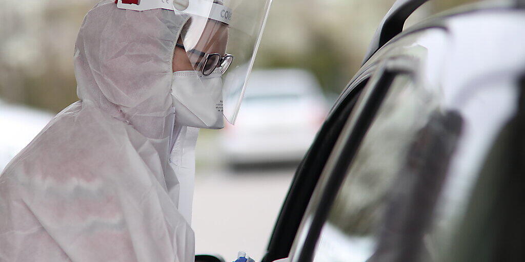 ARCHIV - Ein medizinischer Mitarbeiter im Schutzanzug und mit Gesichtsschutz nimmt in einem mobilen diagnostischen Labor in Warschau Proben von einem Patienten entgegen. Foto: Leszek Szymanski/PAP/dpa ARCHIV - Ein medizinischer Mitarbeiter im Schutzanzug und mit Gesichtsschutz nimmt in einem mobilen diagnostischen Labor in Warschau Proben von einem Patienten entgegen. Foto: Leszek Szymanski/PAP/dpa
