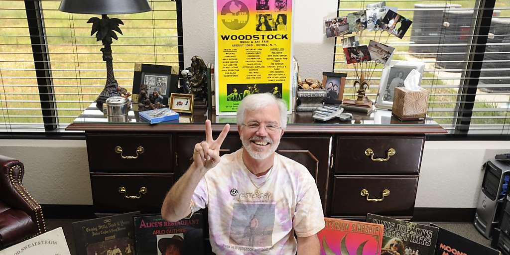 Das Woodstock-Festival vor 50 Jahren hat eine ganze Generation von Musik-Fans geprägt. Im Bild der US-Amerikaner George Hill, der am Festival mit dabei war, umrahmt von zahlreichen Erinnerungen an das legendäre Fest. (Archivbild)