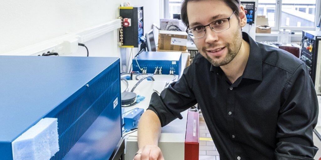 Ruben-Simon Kühnel forscht an wässrigen Elektrolyten für künftige Lithium-Ionen-Zellen. Hier platziert er Versuchszellen in ein Messgerät, um sie wiederholt zu laden und zu entladen.