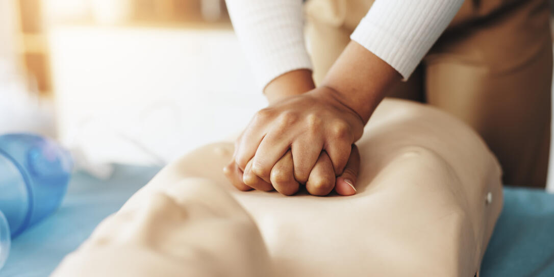 Hands, person and teaching cpr with dummy with demonstration, compression and breathing safety. Woman, mannequin and ventilation process for medical emergency, healthcare protocol and technique steps