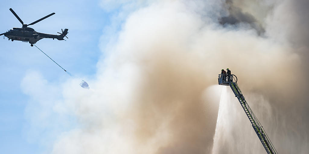Löscharbeiten auf dem Raduner-Areal in Horn TG am Montag. Auch am Dienstag musste die Feuerwehr noch den ganzen Tag immer wieder Glutnester löschen. (Bild: KEYSTONE/Gian Ehrenzeller)
