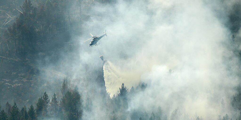 Wie ein Tropfen auf einen heissen Stein: Ein Löschhelikopter wirft über einem Waldbrand bei Ljusdal Wasser ab.
