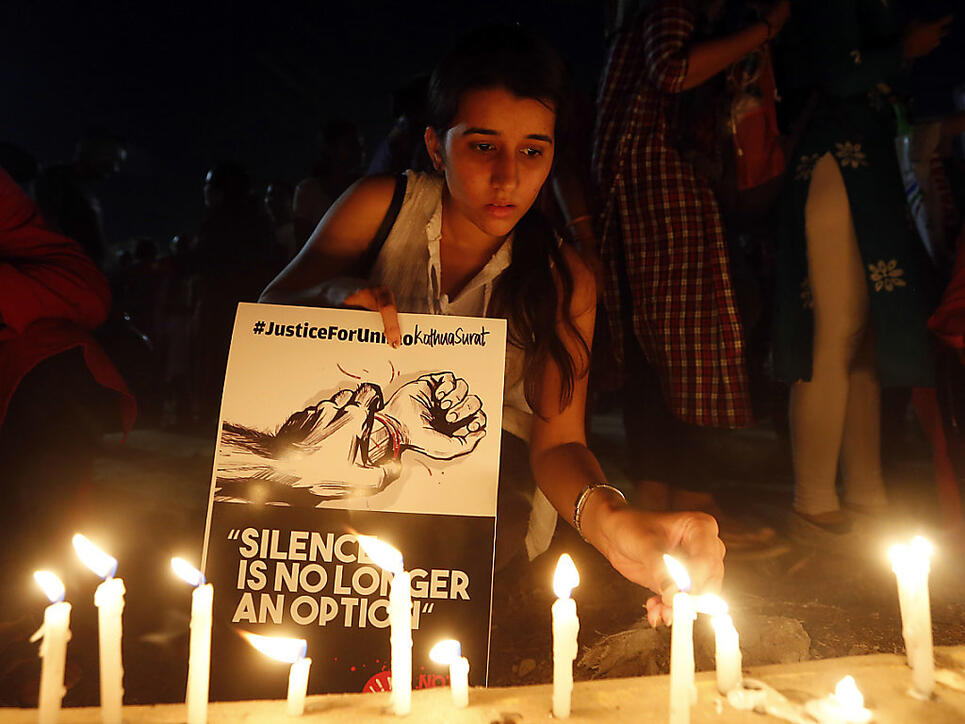 Bei Protesten gegen Vergewaltigungen in Indien zündet eine Jugendliche Kerzen für die Opfer an.