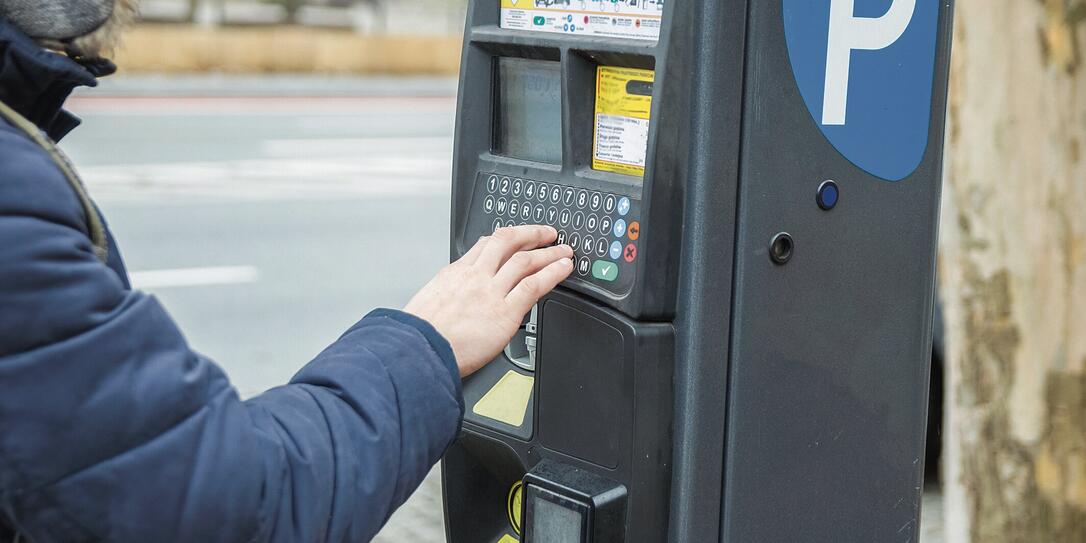 Man pays for parking the car using the parking machine