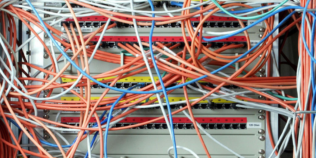 Ein Computer mit Datenkabeln. Das vom Bundestag beschlossene neue Gesetz sieht unter Auflagen Speicherfristen für Telekommunikationsdaten vor (Archiv)