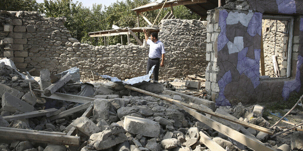Ein Mann steht in den Ruinen eines Hauses, das angeblich während der Kämpfe beschädigt wurde. Foto: Aziz Karimov/AP/dpa