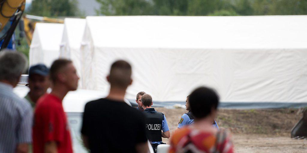 Passanten schauen Polizisten zu, welche die Dresdener Zeltstadt für Flüchtlinge bewachen.