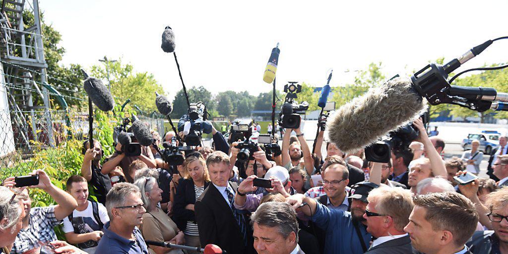 Der deutsche Vizekanzler Sigmar Gabriel spricht nach den rechtsradikalen Krawallen im ostdeutschen Heidenau mit Anwohnern und Journalisten
