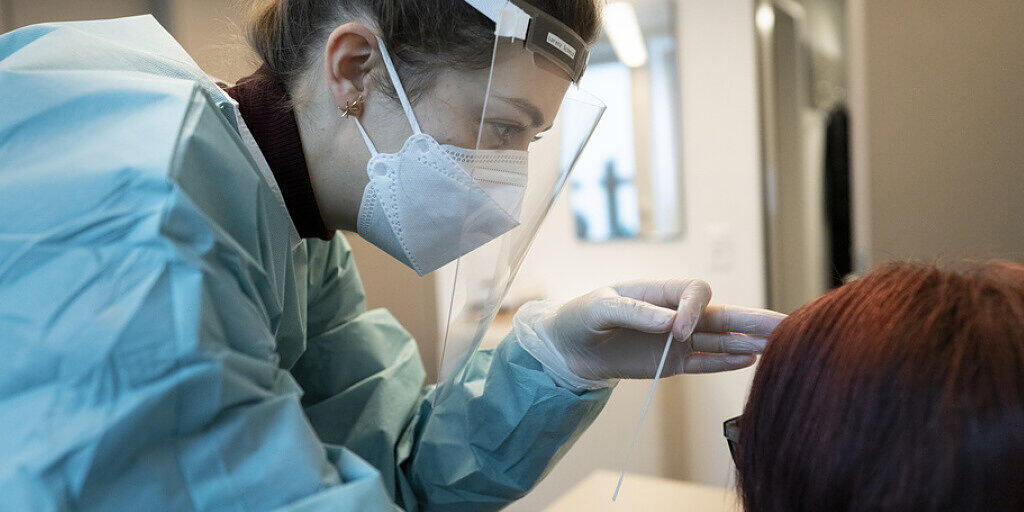 Eine Apothekerin in vorschriftsmässiger Schutzkleidung macht bei einer Frau einen Abstrich für einen Covid-19 Antigen-Schnelltest in der TopPharm Apotheke am Paradeplatz am 3. November in Zürich.
