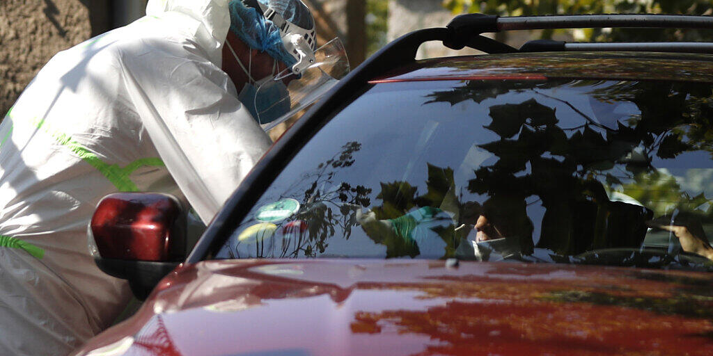 Prag: Ein junger Autofahrer wird an einer Drive-in-Teststation auf Covid-19-Symptome geprüft. In Tschechien breitet sich das Coronavirus weiter rasant aus. Foto: Petr David Josek/AP/dpa