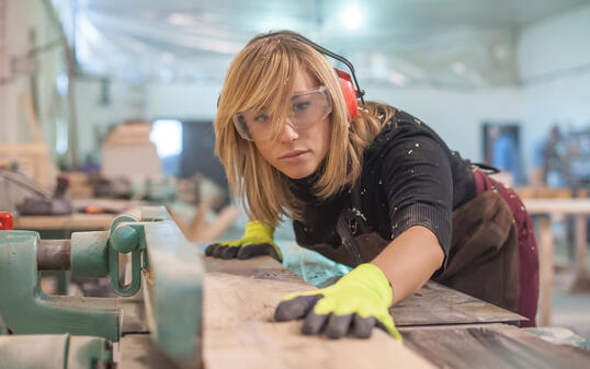 Female carpenter Using Electric Sander