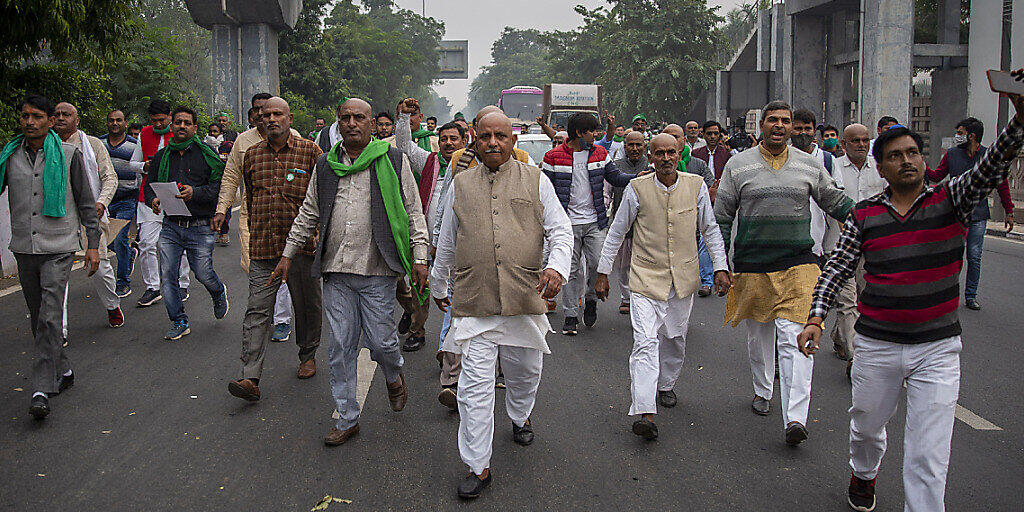 Eine Gruppe indischer Bauern protestiert auf dem Weg zum Wohnsitz des regierenden Mahesh Sharma der Bhartiya Janata Partei. Indische Bauern reichten beim Obersten Gerichtshof eine Petition ein, in der sie die Aufhebung von drei neuen Gesetzen zur Agrarreform fordern. Foto: Altaf Qadri/AP/dpa Eine Gruppe indischer Bauern protestiert auf dem Weg zum Wohnsitz des regierenden Mahesh Sharma der Bhartiya Janata Partei. Indische Bauern reichten beim Obersten Gerichtshof eine Petition ein, in der sie die Aufhebung von drei neuen Gesetzen zur Agrarreform fordern. Foto: Altaf Qadri/AP/dpa