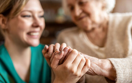 Cropped shot of a senior woman holding hands with a nurse