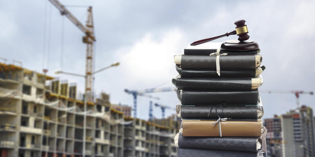 Files with gavel, buildings and cranes