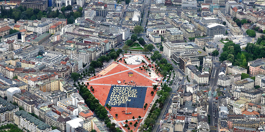 Das grösste Plakat der Welt wirbt für ein bedingungsloses Grundeinkommen: Aus der Helikopterperspektive sieht die 8000 Quadratmeter grosse Affiche auf der Plaine de Plainpalais in Genf winzig klein aus.